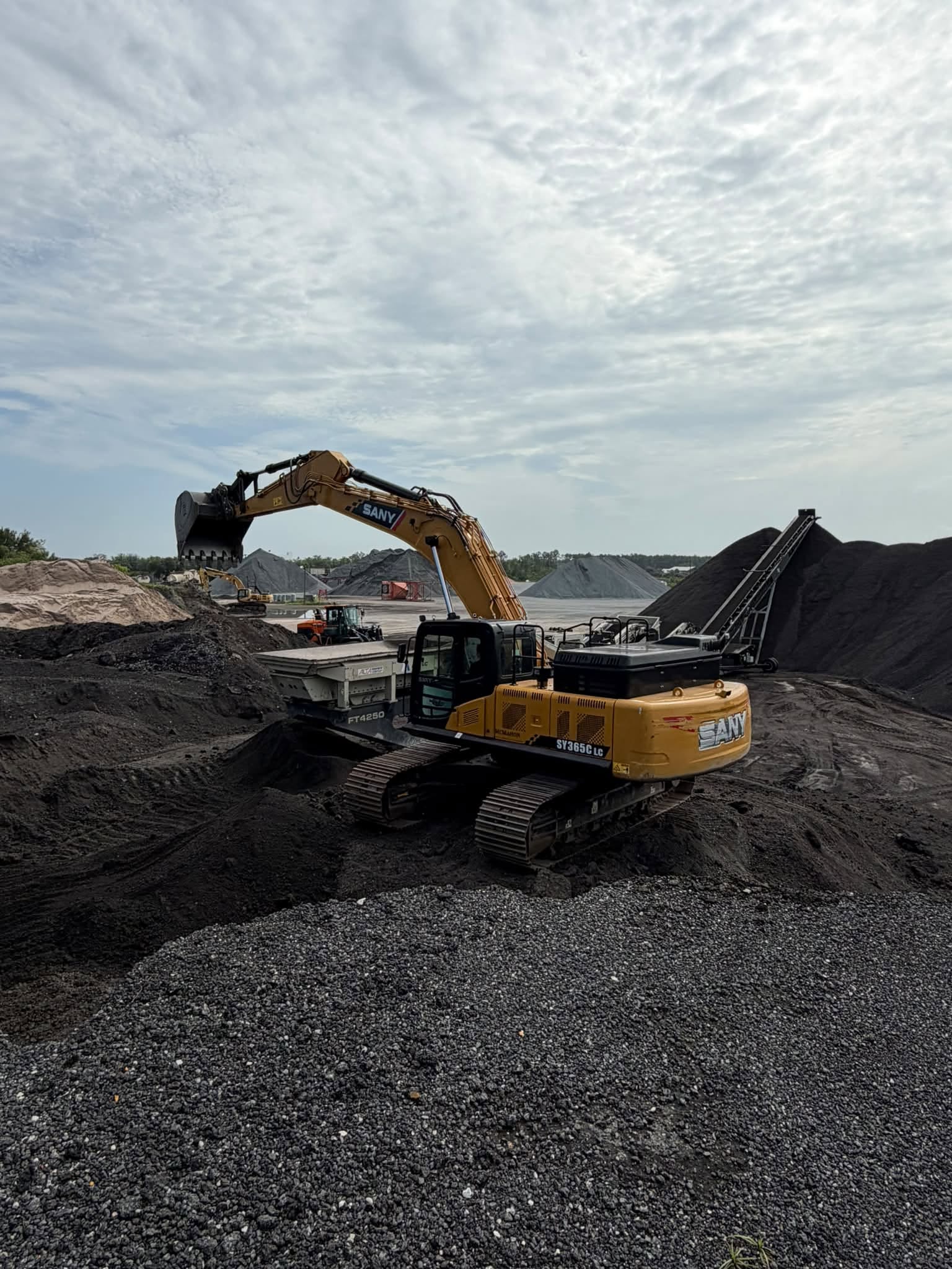 Astec crusher and SANY excavator processing reclaimed asphalt